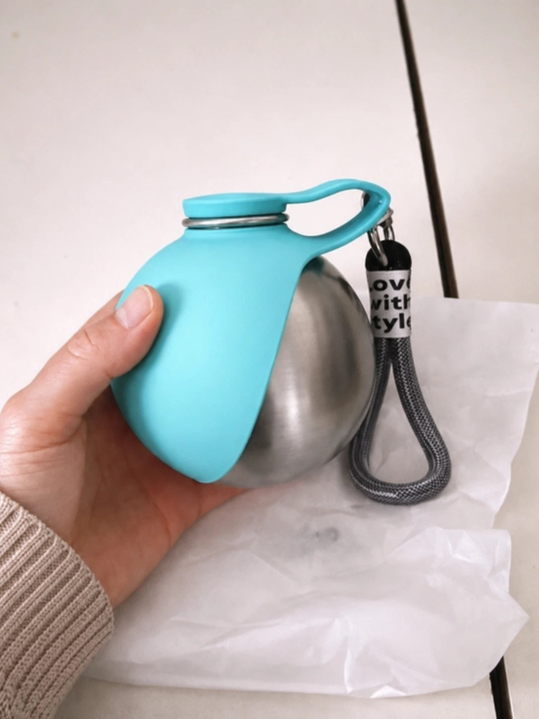 Customer holding the blue PawCoop dog water bottle